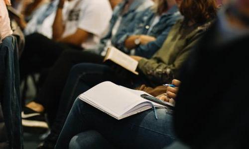 Person taking notes during a meeting.